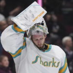 
              San Jose Sharks goalie James Reimer puts his mask back on after taking a drink of water following a Vancouver Canucks goal during the third period of an NHL hockey game Tuesday, Dec. 27, 2022, in Vancouver, British Columbia. (Darryl Dyck/The Canadian Press via AP)
            