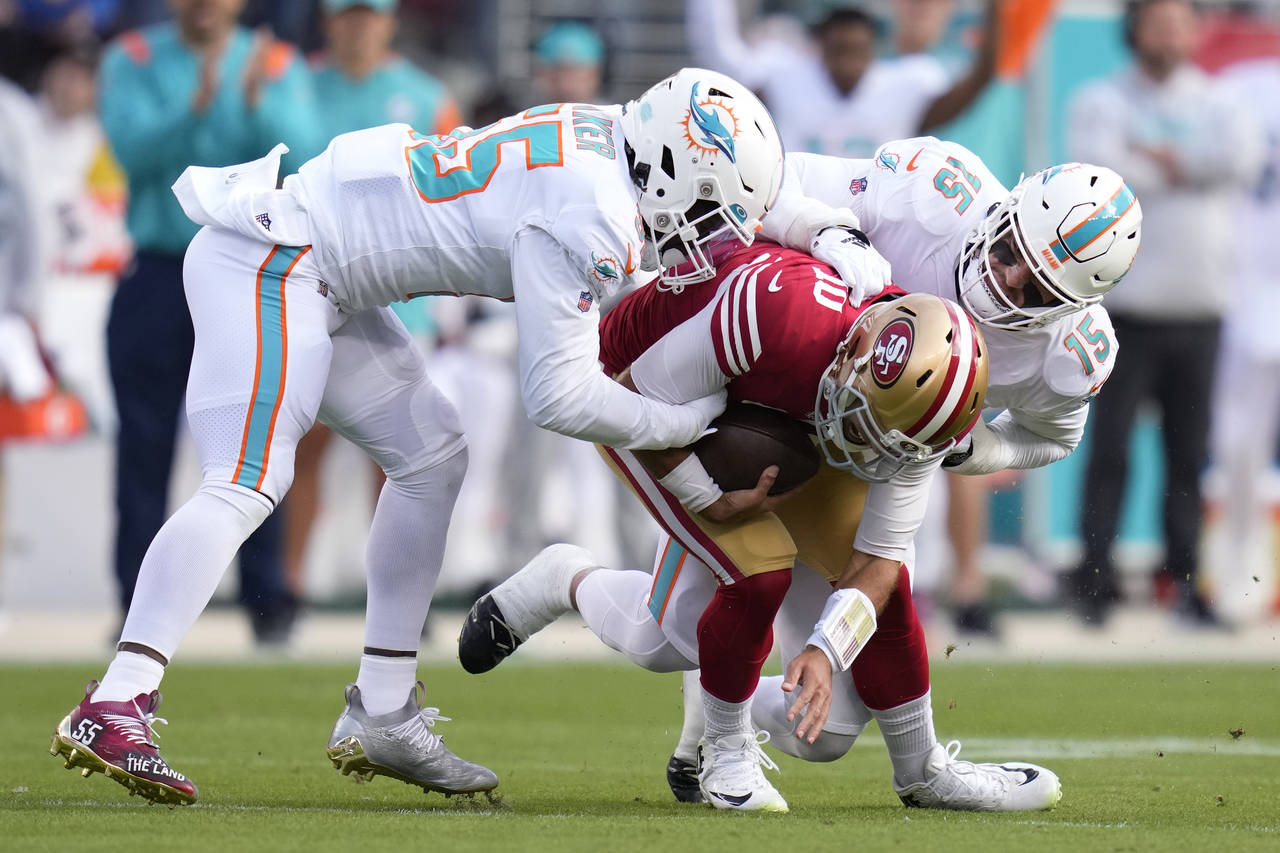 San Francisco 49ers quarterback Jimmy Garoppolo, middle, is sacked by Miami Dolphins linebacker Jer...