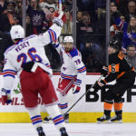 
              New York Rangers' K'Andre Miller, center, celebrates after scoring a goal during the second period of an NHL hockey game against the Philadelphia Flyers, Saturday, Dec. 17, 2022, in Philadelphia. (AP Photo/Derik Hamilton)
            