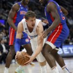
              Orlando Magic center Moritz Wagner (21) looks to pass the ball from between Detroit Pistons center Isaiah Stewart, right, and center Jalen Duren, left, during the first half of an NBA basketball game Wednesday, Dec. 28, 2022, in Detroit. (AP Photo/Duane Burleson)
            
