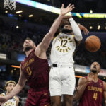 
              Indiana Pacers forward Oshae Brissett (12) and Cleveland Cavaliers forward Kevin Love (0) vie for a rebound during the first half of an NBA basketball game in Indianapolis, Thursday, Dec. 29, 2022. (AP Photo/AJ Mast)
            
