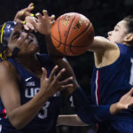
              Connecticut's Aaliyah Edwards (3) and Lou Lopez Sénéchal (11) fight with Notre Dame's Lauren Ebo, in back, for a rebound during the first half of an NCAA college basketball game, Sunday, Dec. 4, 2022, in South Bend, Ind. (AP Photo/Michael Caterina)
            
