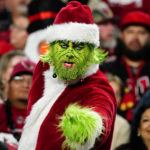 
              A fan dressed as the Grinch watches play during the first half of an NFL football game between the Arizona Cardinals and the Tampa Bay Buccaneers, Sunday, Dec. 25, 2022, in Glendale, Ariz. (AP Photo/Darryl Webb)
            