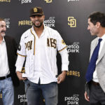 
              San Diego Padres' Xander Bogaerts, center, puts on his Padres jersey as Padres general manager A.J. Preller, right, and Padres Chairman Peter Seidler look on at a news conference held to announce that Bogaerts' $280 million, 11-year contact with the team has been finalized, Friday, Dec. 9, 2022, in San Diego. (AP Photo/Denis Poroy)
            