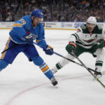 
              St. Louis Blues' Pavel Buchnevich (89) passes around Minnesota Wild's Marcus Foligno (17) during the second period of an NHL hockey game Saturday, Dec. 31, 2022, in St. Louis. (AP Photo/Jeff Roberson)
            