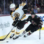
              Boston Bruins defenseman Connor Clifton (75) skates with the puck against Arizona Coyotes center Travis Boyd (72) during the first period of an NHL hockey game in Tempe, Ariz., Friday, Dec. 9, 2022. (AP Photo/Ross D. Franklin)
            