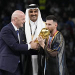 
              Argentina's Lionel Messi receives the trophy from FIFA President Gianni Infantino, left, and the Emir of Qatar Sheikh Tamim bin Hamad Al Thani, after winning the World Cup final soccer match between Argentina and France at the Lusail Stadium in Lusail, Qatar, Sunday, Dec. 18, 2022. Argentina won 4-2 in a penalty shootout after the match ended tied 3-3. (AP Photo/Martin Meissner)
            
