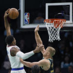 
              New York Knicks guard RJ Barrett, left, drives for a dunk against Charlotte Hornets center Mason Plumlee during the first half of an NBA basketball game in Charlotte, N.C., Friday, Dec. 9, 2022. (AP Photo/Nell Redmond)
            