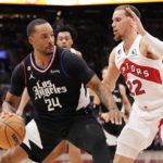 
              Los Angeles Clippers forward Norman Powell (24) protects the ball from Toronto Raptors guard Malachi Flynn (22) during the first half of an NBA basketball game Tuesday, Dec. 27, 2022, in Toronto. (Frank Gunn/The Canadian Press via AP)
            