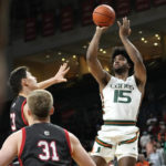 
              Miami forward Norchad Omier (15) shoots over St. Francis forward Josh Cohen (33) during the first half of an NCAA college basketball game, Saturday, Dec. 17, 2022, in Coral Gables, Fla. (AP Photo/Lynne Sladky)
            
