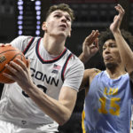 
              Connecticut's Donovan Clingan, left, drives to the basket as Long Island's C.J. Delancy defends during the first half of an NCAA college basketball game, Saturday, Dec. 10, 2022, in Storrs, Conn. (AP Photo/Jessica Hill)
            