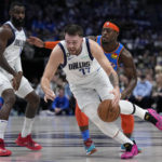
              Dallas Mavericks guard Luka Doncic (77) moves to the basket after getting around Oklahoma City Thunder's Luguentz Dort, right rear, with help from Mavericks forward Tim Hardaway Jr., left, in the first half of an NBA basketball game, Monday, Dec. 12, 2022, in Dallas. (AP Photo/Tony Gutierrez)
            