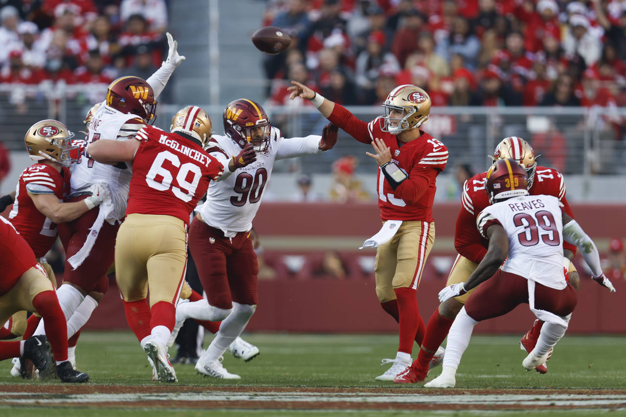 San Francisco 49ers quarterback Brock Purdy (13) throws to a receiver as he is pressured by Washing...