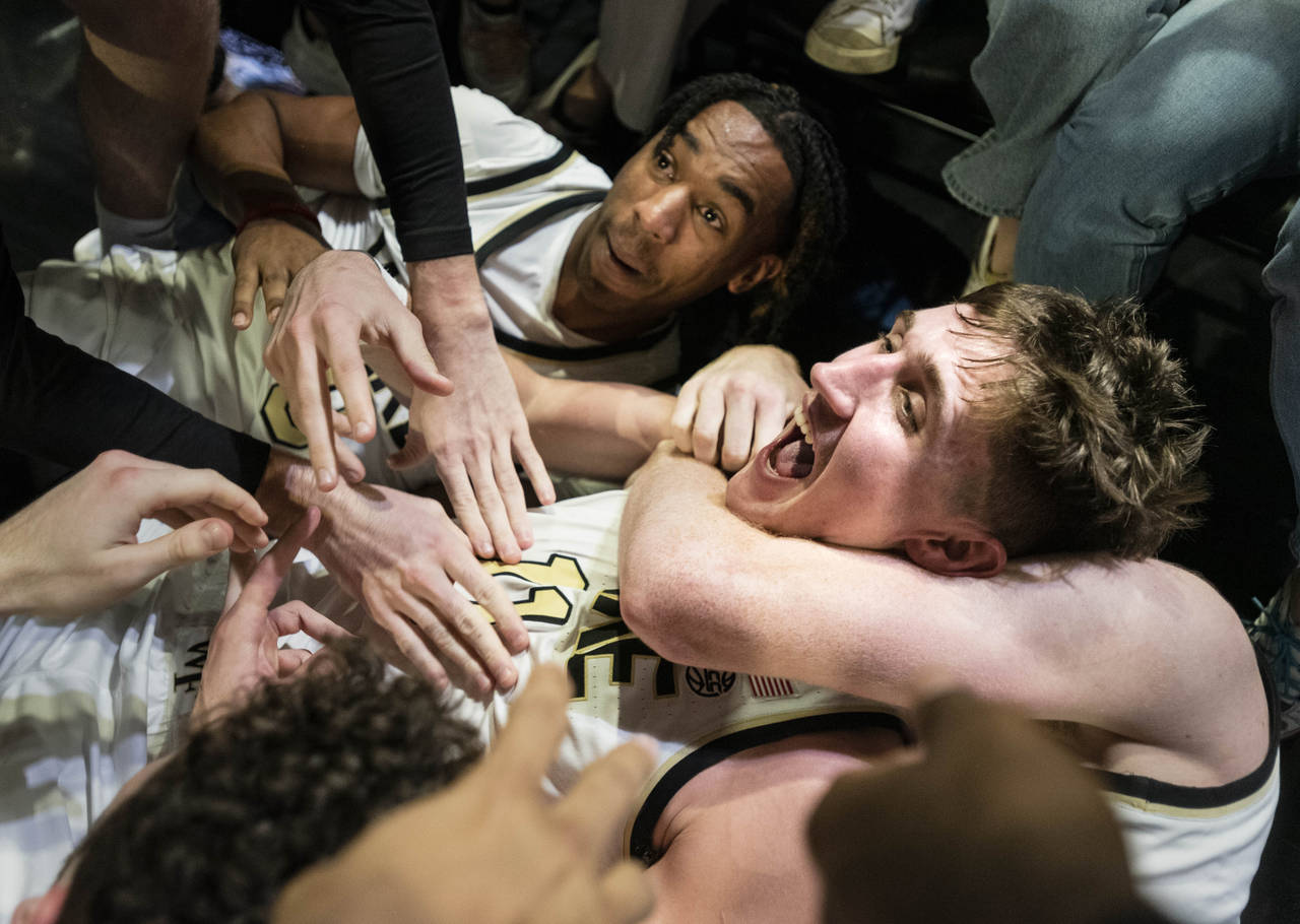 Wake Forest forward Andrew Carr, center, is hugged by teammates Lucas Taylor, left, and Cameron Hil...