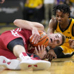 
              Wisconsin forward Tyler Wahl, left, fights for a loose ball with Iowa guard Dasonte Bowen during the first half of an NCAA college basketball game, Sunday, Dec. 11, 2022, in Iowa City, Iowa. (AP Photo/Charlie Neibergall)
            