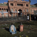 
              Soccer fans sit on the plaza of the Casa Rosada presidential palace, after waiting for hours for a homecoming parade for the players who won the World Cup title, in Buenos Aires, Argentina, Tuesday, Dec. 20, 2022. A parade to celebrate the Argentine World Cup champions was abruptly cut short Tuesday as millions of people poured onto thoroughfares, highways and overpasses in a chaotic attempt to catch a glimpse of the national team. (AP Photo/Rodrigo Abd)
            