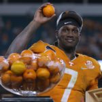 
              Tennessee quarterback Joe Milton III (7) throws oranges from the trophy to teammates after Tennessee defeated Clemson in the Orange Bowl NCAA college football game, early Saturday, Dec. 31, 2022, in Miami Gardens, Fla. (AP Photo/Rebecca Blackwell)
            