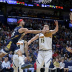 
              New Orleans Pelicans guard Jose Alvarado, front left, passes the ball around Denver Nuggets center Nikola Jokic, center, in the first half of an NBA basketball game in New Orleans, Sunday, Dec. 4, 2022. (AP Photo/Matthew Hinton)
            