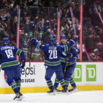 
              Vancouver Canucks' Elias Pettersson, back, of Sweden, Curtis Lazar (20), Quinn Hughes, back right, and Jack Studnicka (18) celebrate Pettersson's winning goal against the Montreal Canadiens during overtime in an NHL hockey game in Vancouver, British Columbia, Monday, Dec. 5, 2022. (Darryl Dyck/The Canadian Press via AP)
            