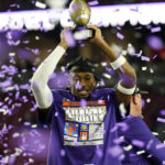 
              TCU wide receiver Quentin Johnston holds the trophy after the Fiesta Bowl NCAA college football semifinal playoff game, Saturday, Dec. 31, 2022, in Glendale, Ariz. TCU defeated Michigan 51-45. (AP Photo/Ross D. Franklin)
            