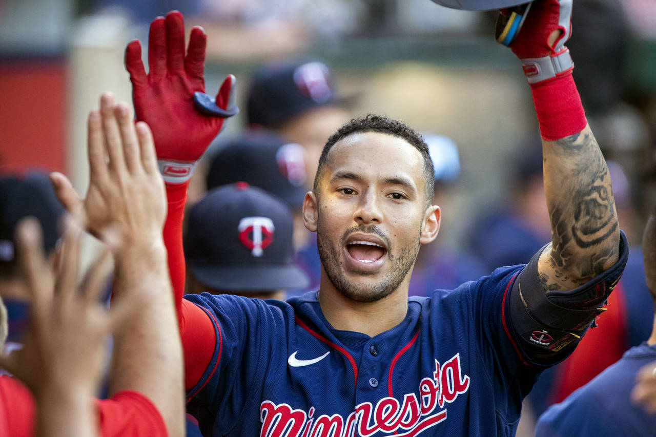 FILE - Minnesota Twins' Carlos Correa, right, is congratulated after hitting a solo home run agains...