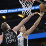 
              Orlando Magic forward Franz Wagner (22) goes up for a shot in front of San Antonio Spurs center Jakob Poeltl (25) during the first half of an NBA basketball game Friday, Dec. 23, 2022, in Orlando, Fla. (AP Photo/Phelan M. Ebenhack)
            