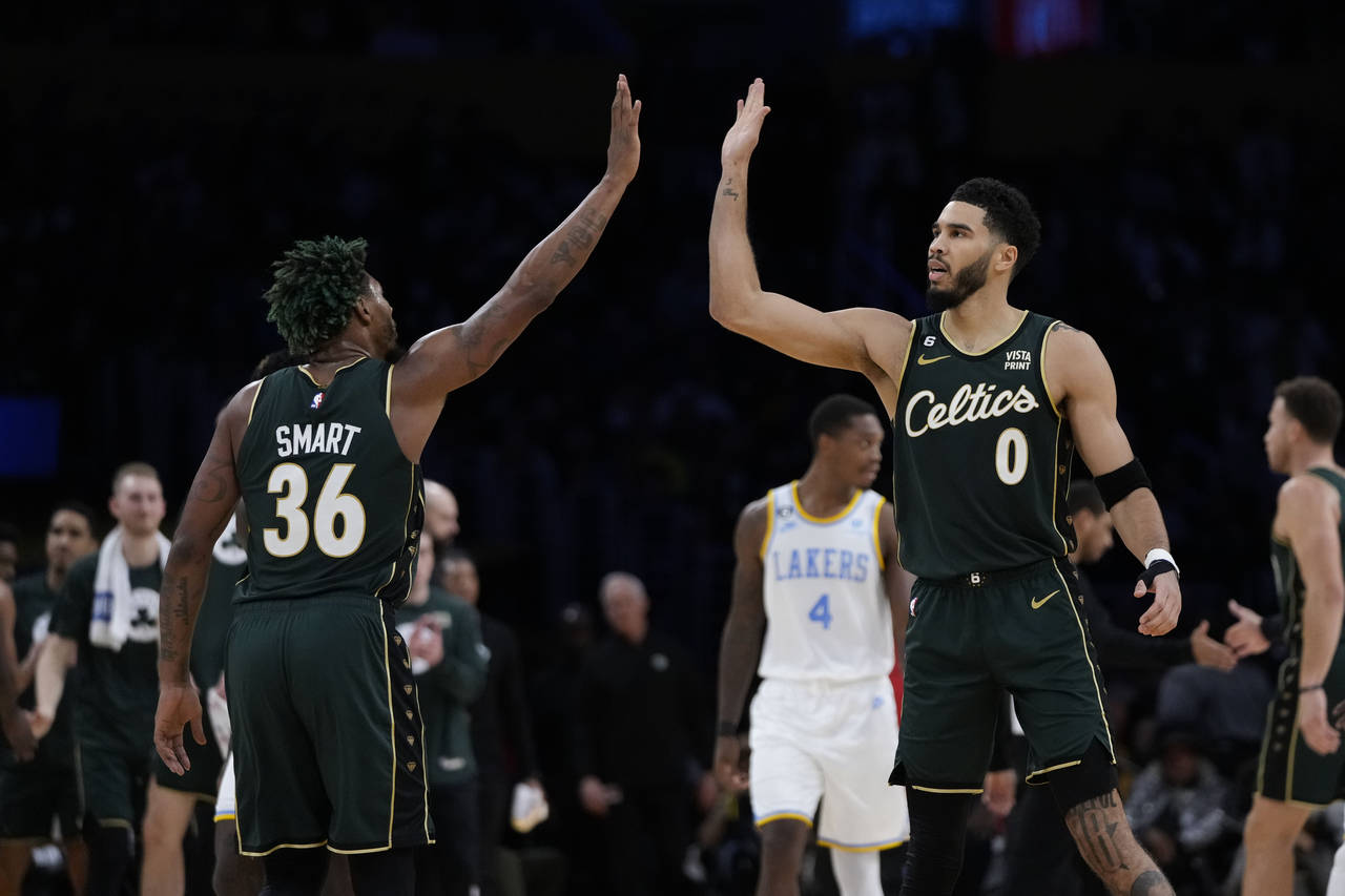 Boston Celtics' Jayson Tatum (0) and Marcus Smart (36) high-five during first half of an NBA basket...