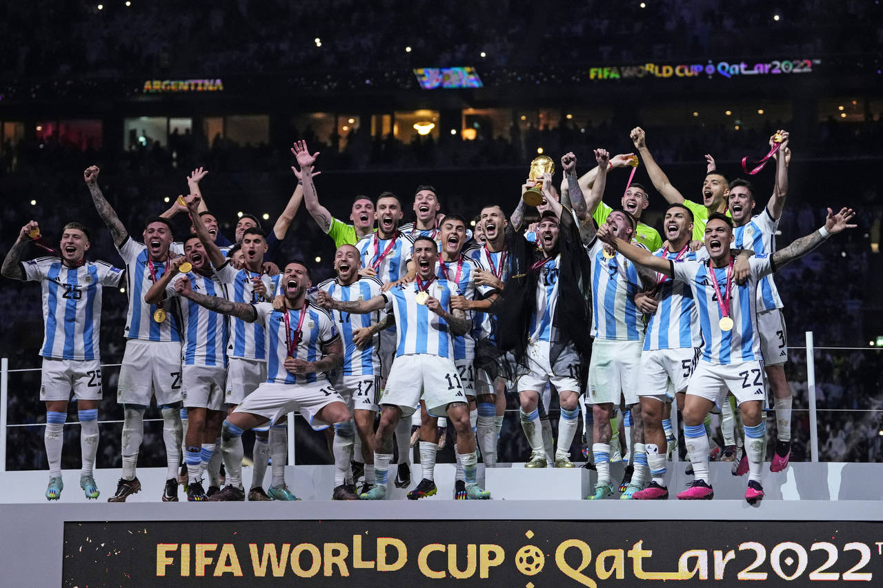 Argentina's Lionel Messi holds up the trophy after winning the World Cup final soccer match between...