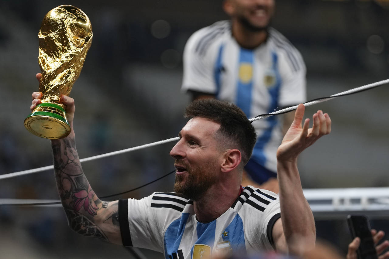 Argentina's Lionel Messi celebrates with the trophy after winning the World Cup final soccer match ...