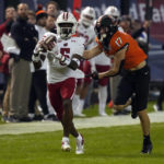 
              Wisconsin cornerback Cedrick Dort Jr. intercepts the football in front of Oklahoma State wide receiver John Paul Richardson (17) during the second half of the Guaranteed Rate Bowl NCAA college football game Tuesday, Dec. 27, 2022, in Phoenix. Wisconsin 24-17. (AP Photo/Rick Scuteri)
            