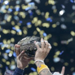 
              Michigan wide receiver Ronnie Bell holds the trophy after defeating Purdue in the Big Ten championship NCAA college football game, early Sunday, Dec. 4, 2022, in Indianapolis. Michigan won, 43-22. (AP Photo/Darron Cummings)
            