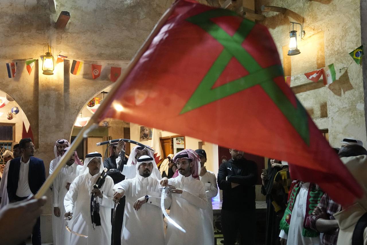 A man waves a Moroccan flag as people celebrate in the Souq in Doha, Qatar after Morocco beat Portu...