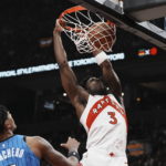 
              Toronto Raptors' O.G. Anunoby dunks on Orlando Magic's Paolo Banchero during the first half of an NBA basketball game, Saturday, Dec. 3, 2022 in Toronto. (Chris Young/The Canadian Press via AP)
            