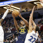 
              Indiana Pacers center Myles Turner (33) shoots on Minnesota Timberwolves center Rudy Gobert (27) and Timberwolves forward Jaden McDaniels (3) in the third quarter of an NBA basketball game, Wednesday, Dec. 7, 2022, in Minneapolis. (AP Photo/Andy Clayton-King)
            