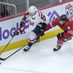 
              Washington Capitals' Aliaksei Protas (59) and Chicago Blackhawks' Jack Johnson battles for the puck during the second period of an NHL hockey game Tuesday, Dec. 13, 2022, in Chicago. (AP Photo/Charles Rex Arbogast)
            