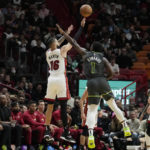 
              Miami Heat forward Caleb Martin (16) shoots as Minnesota Timberwolves guard Anthony Edwards (1) defends during the first half of an NBA basketball game, Monday, Dec. 26, 2022, in Miami. (AP Photo/Lynne Sladky)
            