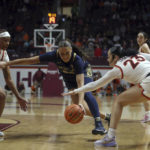 
              Notre Dame's Kylee Watson, center, loses control of the ball while defended by Virginia Tech's D'asia Gregg, left, and Kayana Traylor (23) right, in the first half of an NCAA college basketball game in Blacksburg, Va., Sunday, Dec. 18, 2022. (Matt Gentry/The Roanoke Times via AP)
            