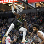 
              Minnesota Timberwolves guard Jaylen Nowell (4) hangs on the rim after a dunk during the second half of an NBA basketball game against the Detroit Pistons, Saturday, Dec. 31, 2022, in Minneapolis. (AP Photo/Abbie Parr)
            