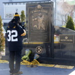 
              A fan takes a photo of the flowers and Terrible Towels placed at the Immaculate Reception memorial outside Acrisure Stadium on the Northside of Pittsburgh in memory of Pittsburgh Steelers Pro Football Hall of Fame running back Franco Harris, Wednesday, Dec. 21, 2022. Franco Harris has died. He was 72. Harris' son, Dok, told The Associated Press on Wednesday that his father died overnight. (AP Photo/Gene J. Puskar, File)
            
