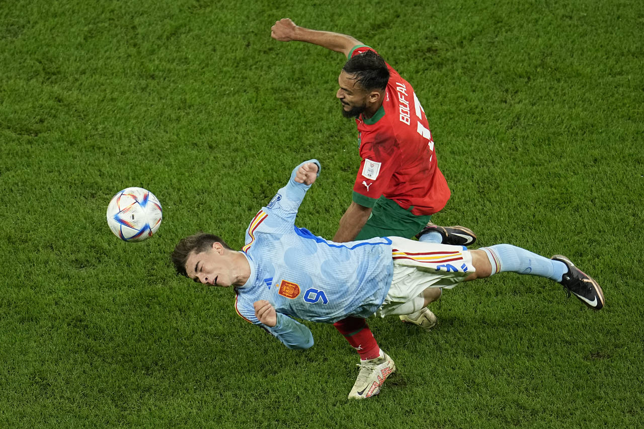 Morocco's Sofiane Boufal in action against Spain's Gavi, bottom, during the World Cup round of 16 s...