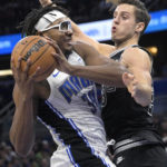 
              Orlando Magic center Wendell Carter Jr. (34) is fouled by San Antonio Spurs forward Zach Collins (23) while driving to the basket during the first half of an NBA basketball game Friday, Dec. 23, 2022, in Orlando, Fla. (AP Photo/Phelan M. Ebenhack)
            