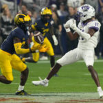 
              Michigan defensive back Mike Sainristil, left, intercepts a pass intended for TCU wide receiver Derius Davis (11) during the second half of the Fiesta Bowl NCAA college football semifinal playoff game, Saturday, Dec. 31, 2022, in Glendale, Ariz. (AP Photo/Rick Scuteri)
            