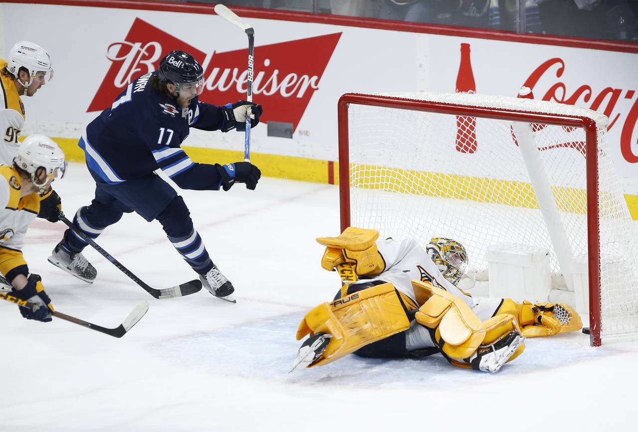 Winnipeg Jets' Adam Lowry (17) celebrates as Kyle Connor's (not shown) shot sneaks through the pads...