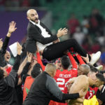 
              Morocco's head coach Walid Regragui is thrown in the air by players after the World Cup quarterfinal soccer match between Morocco and Portugal, at Al Thumama Stadium in Doha, Qatar, Saturday, Dec. 10, 2022. (AP Photo/Martin Meissner)
            