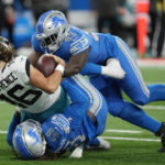 
              Jacksonville Jaguars quarterback Trevor Lawrence (16) is sacked by Detroit Lions linebacker James Houston (59) and defensive end Josh Paschal (93) during the first half of an NFL football game, Sunday, Dec. 4, 2022, in Detroit. (AP Photo/Paul Sancya)
            