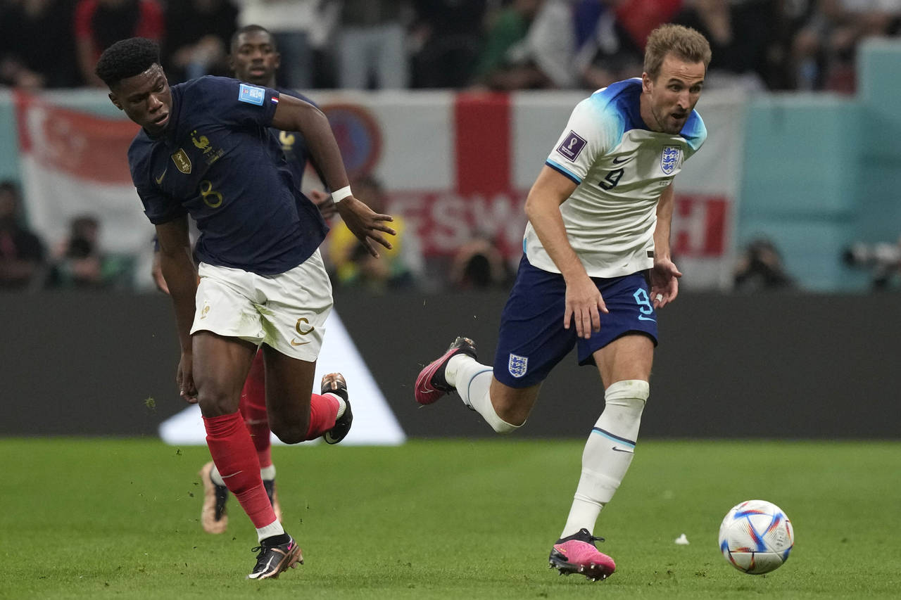 England's Harry Kane, right, and France's Aurelien Tchouameni challenge for the ball during the Wor...