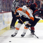
              Philadelphia Flyers' Kevin Hayes (13) collides with Carolina Hurricanes' Jordan Martinook, right, while stealing the puck during the first period of an NHL hockey game in Raleigh, N.C., Friday, Dec. 23, 2022. (AP Photo/Karl B DeBlaker)
            