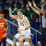 
              Notre Dame's Dane Goodwin (23) celebrates making a shot as Syracuse's Benny Williams (13) also runs up the court during the first half of an NCAA college basketball game on Saturday, Dec. 3, 2022 in South Bend, Ind. (AP Photo/Michael Caterina)
            