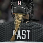 
              A braid hangs out of the back of the helmet of Canada defender Renata Fast (14) during the second period of a Rivalry Series hockey game against the United States Monday, Dec. 19, 2022, in Los Angeles. (AP Photo/Ashley Landis)
            