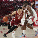 
              Alabama guard Jahvon Quinerly (5) drives past Houston guard Marcus Sasser (0) and forward Jarace Walker (25) on his way to score during the first half of an NCAA college basketball game, Saturday, Dec. 10, 2022, in Houston. (AP Photo/Kevin M. Cox)
            